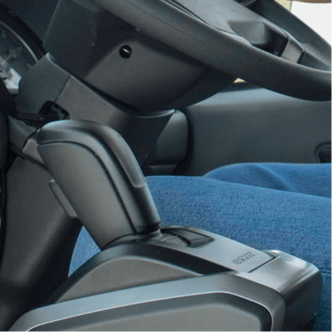 Tuas gear automatik kereta dengan pemilik memakai seluar jeans biru.