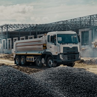 ဆောက်လုပ်ရေးနေရာတွင်အေးအောက်ထရပ်ကား၊ နောက်ဘက်မှာအဆောက်အအုံတည်နေသည်။