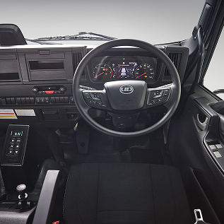 Modern truck dashboard and steering wheel, black seat in foreground.