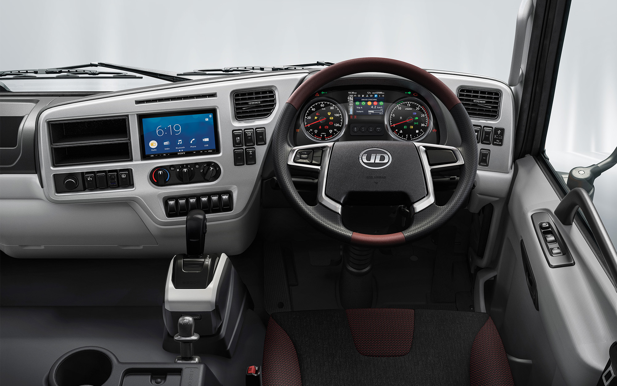 Modern truck dashboard with digital displays, gauges, and a steering wheel.